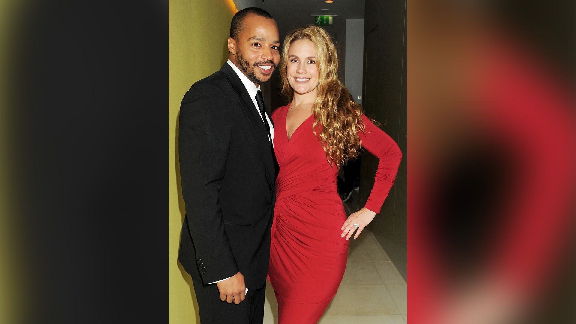 Donald Faison num blazer preto e CaCee Cobb num vestido comprido vermelho