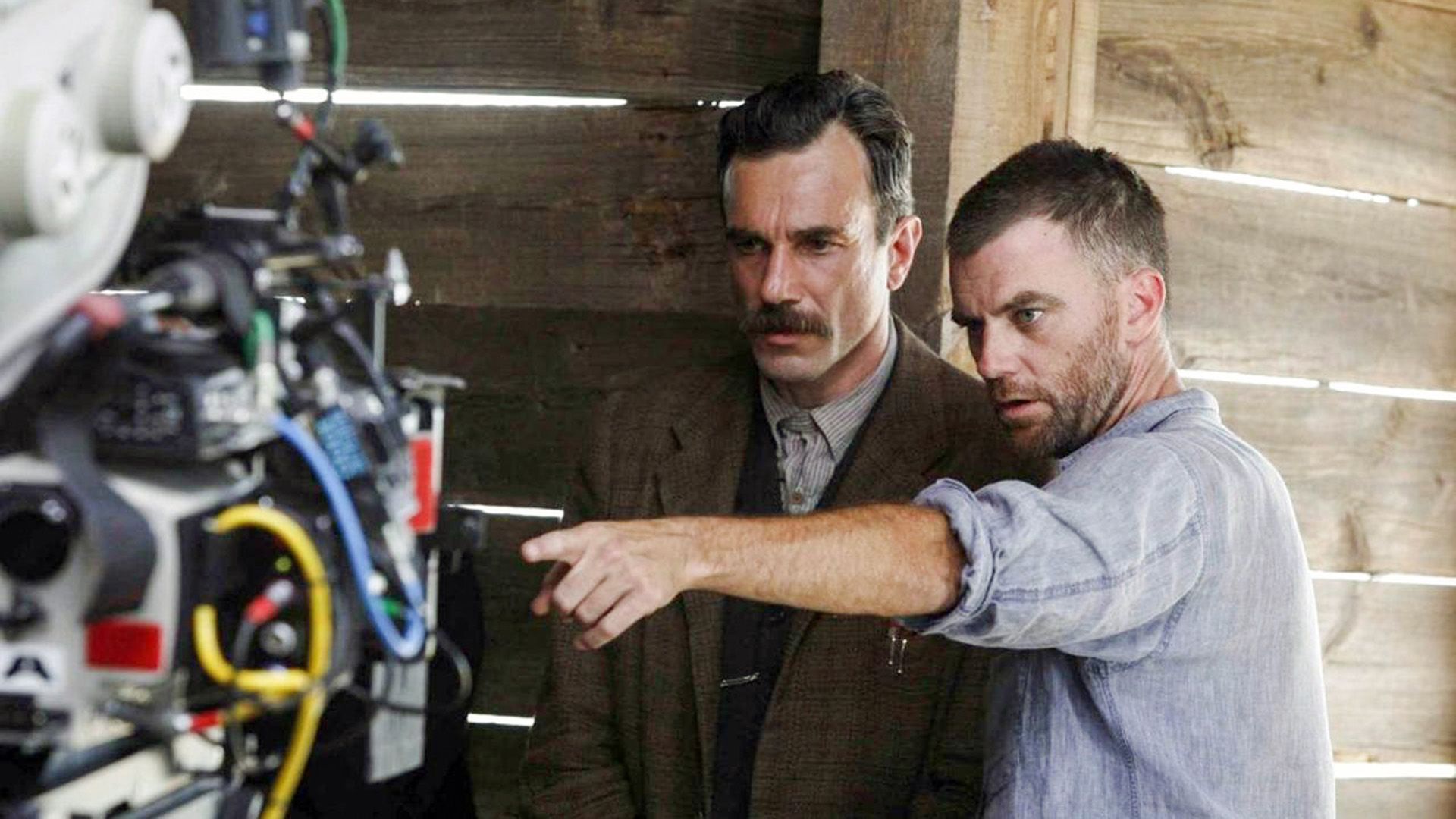 Paul Thomas Anderson apontando Daniel Day-Lewis em direção à câmara com a mão