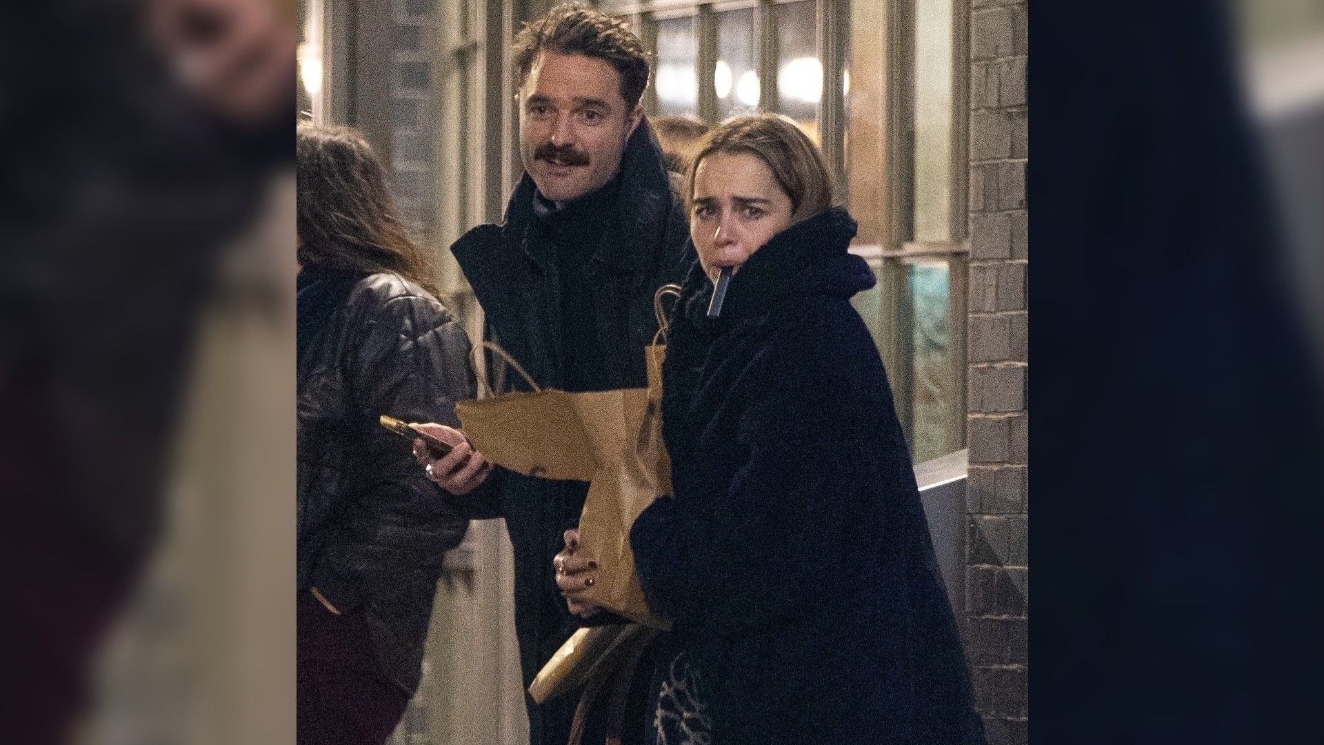 Emilia Clarke e Bassi Fox a caminhar na rua com roupa de inverno