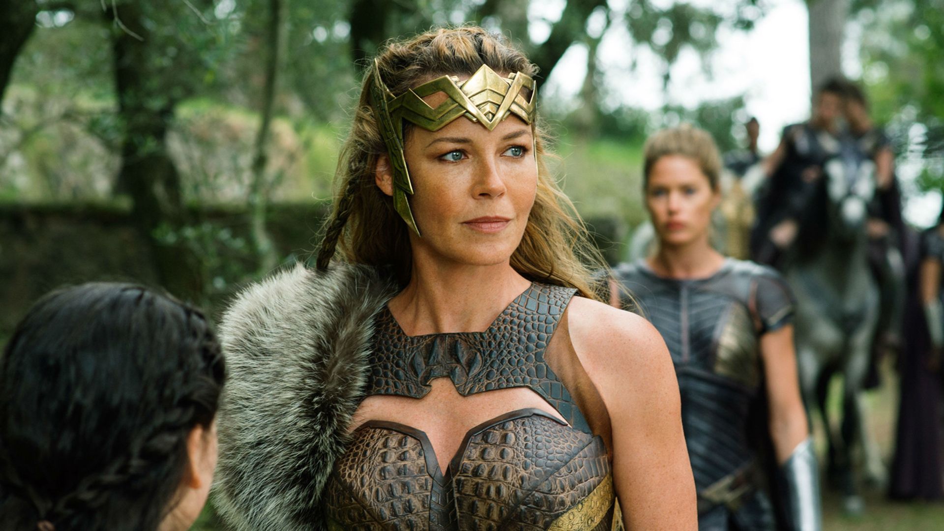 Connie Nielsen em armadura de couro e coroa dourada de amazona
