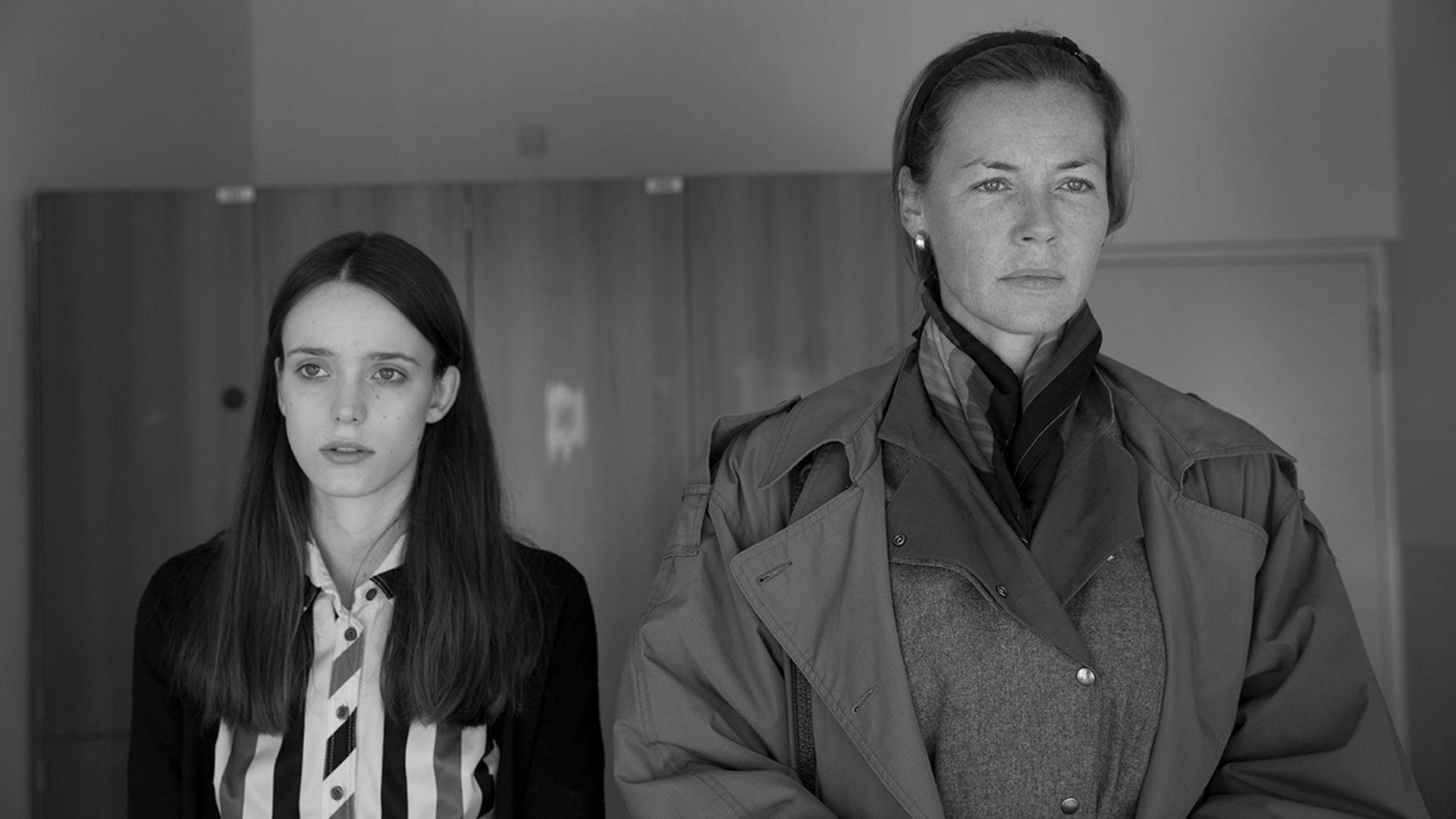 Connie Nielsen com expressão séria ao lado de uma menina