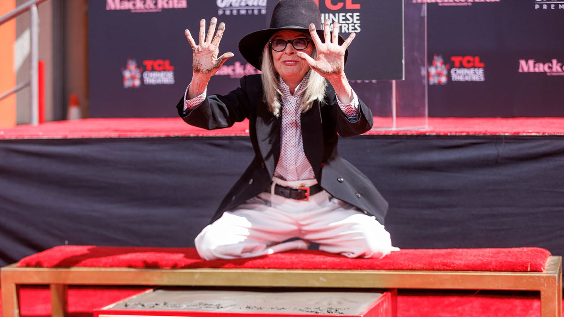 Diane Keaton, de chapéu e fato de calças, deixa as suas impressões de mãos no cimento