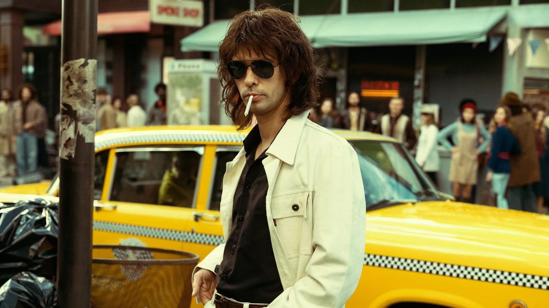 Ben Whishaw de cabeleira comprida e óculos aviador, fotograma de Limonov