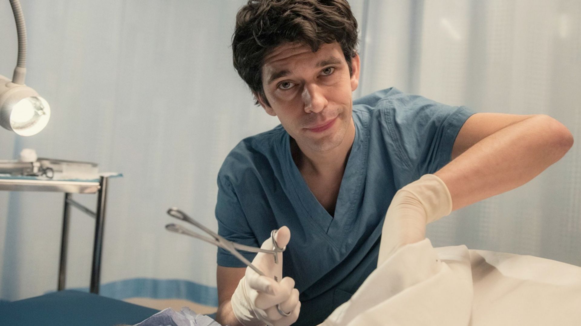Ben Whishaw em roupa de médico segurando um instrumento médico, cena da série This Is Going to Hurt