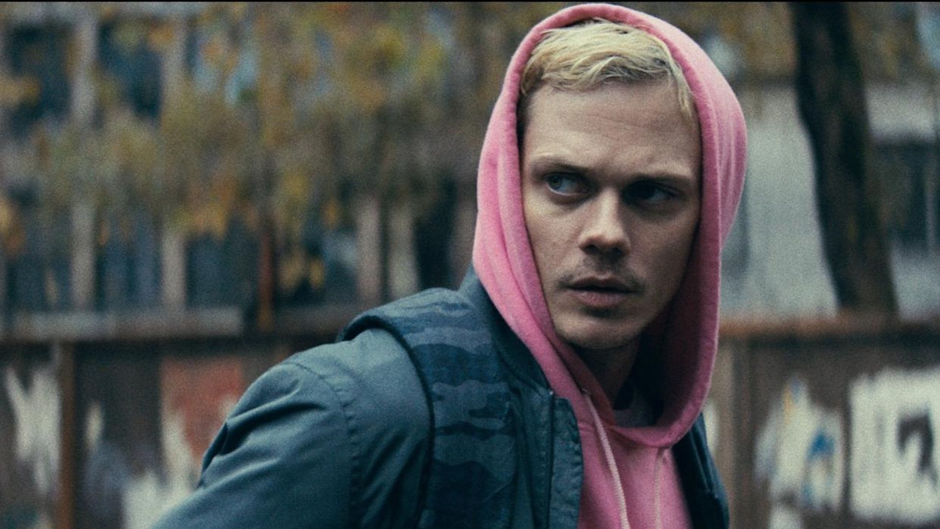Bill Skarsgård num hoodie cor-de-rosa