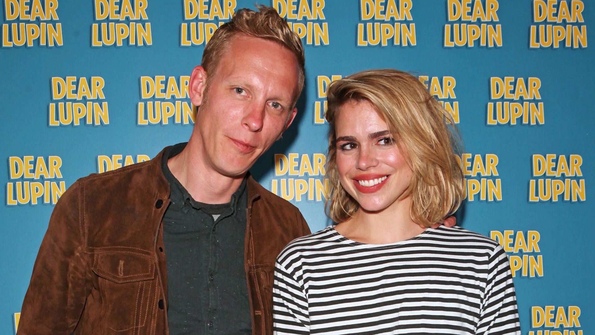 Billie Piper com uma camisola às riscas e Laurence Fox com um casaco castanho contra um fundo azul