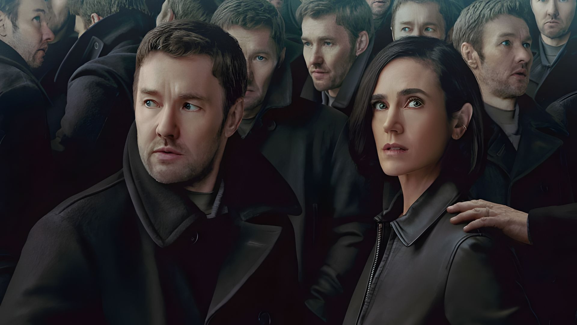 Joel Edgerton e Jennifer Connelly com casacos, no meio de uma multidão