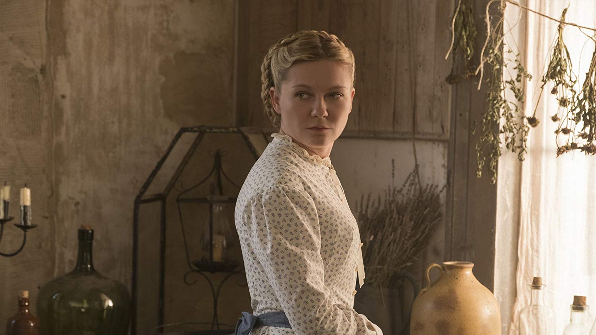 Kirsten Dunst num vestido branco vintage numa pose de três quartos