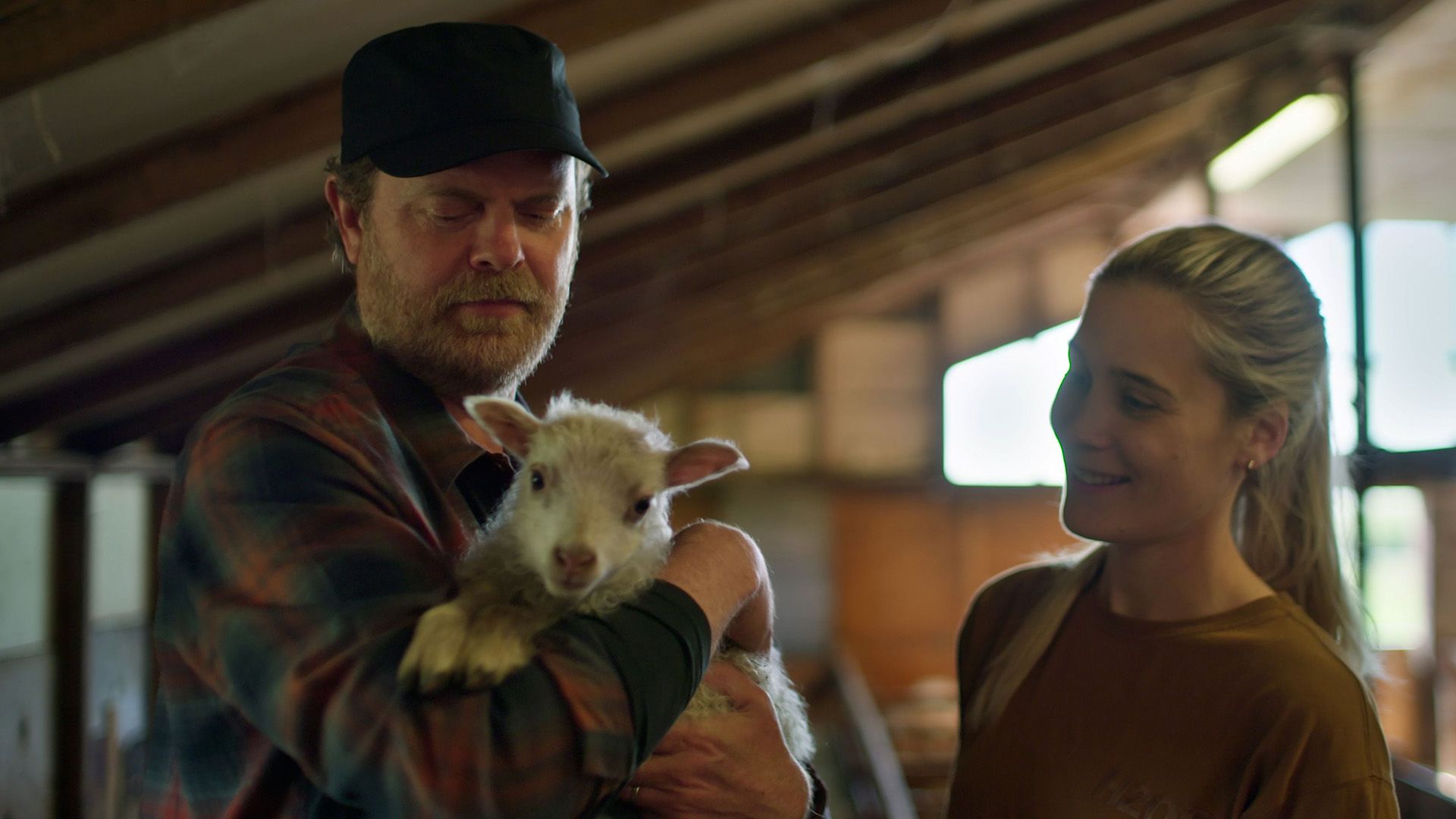 Rainn Wilson a segurar uma cabra bebé com uma rapariga sorridente ao seu lado
