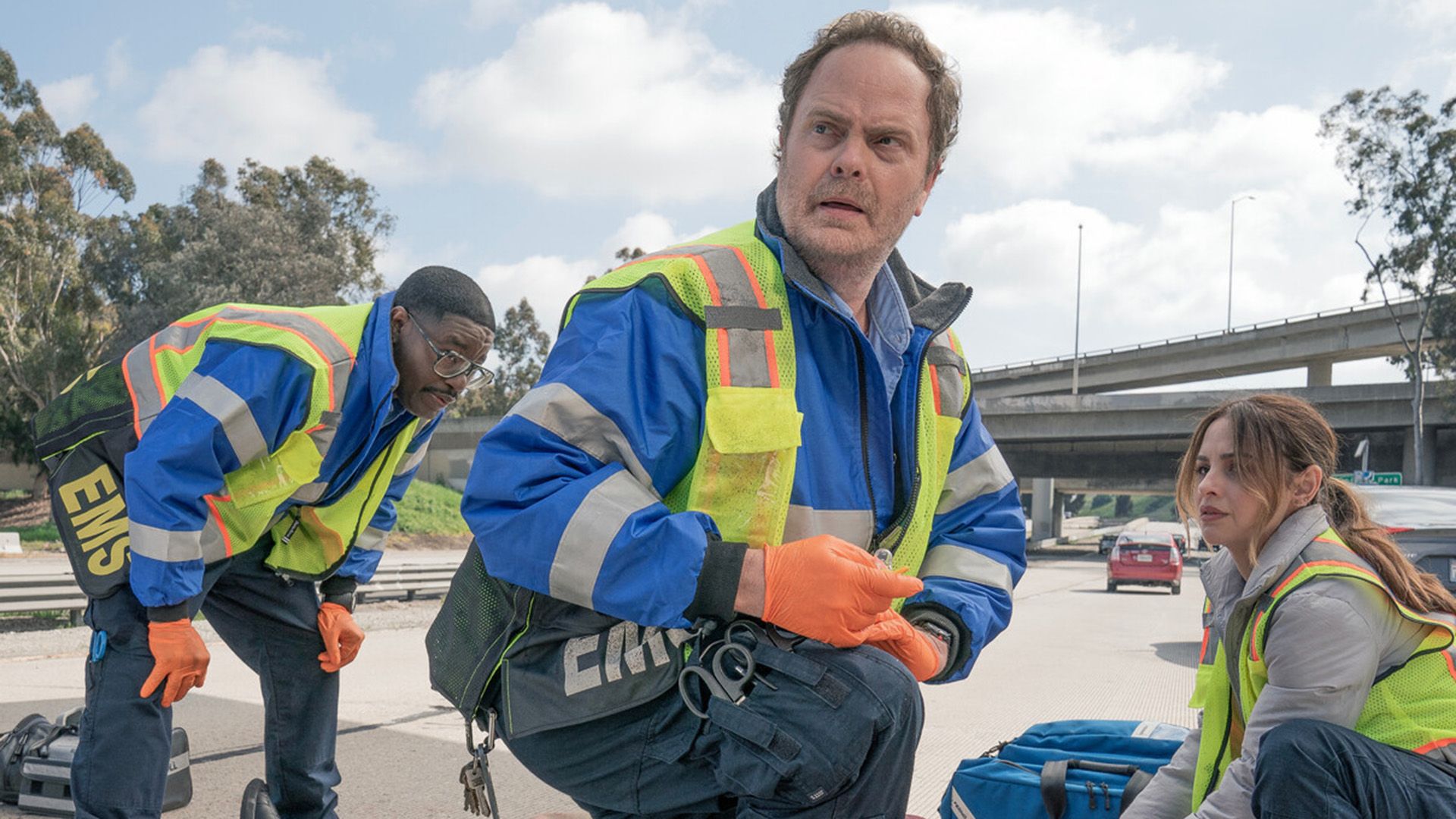 Rainn Wilson em uniforme de paramédico com expressão preocupada
