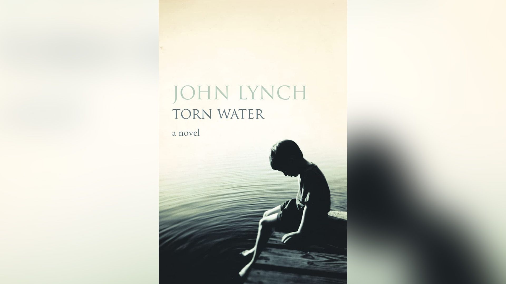 Capa do livro "Torn Water": um rapaz sentado num cais com as pernas penduradas na água