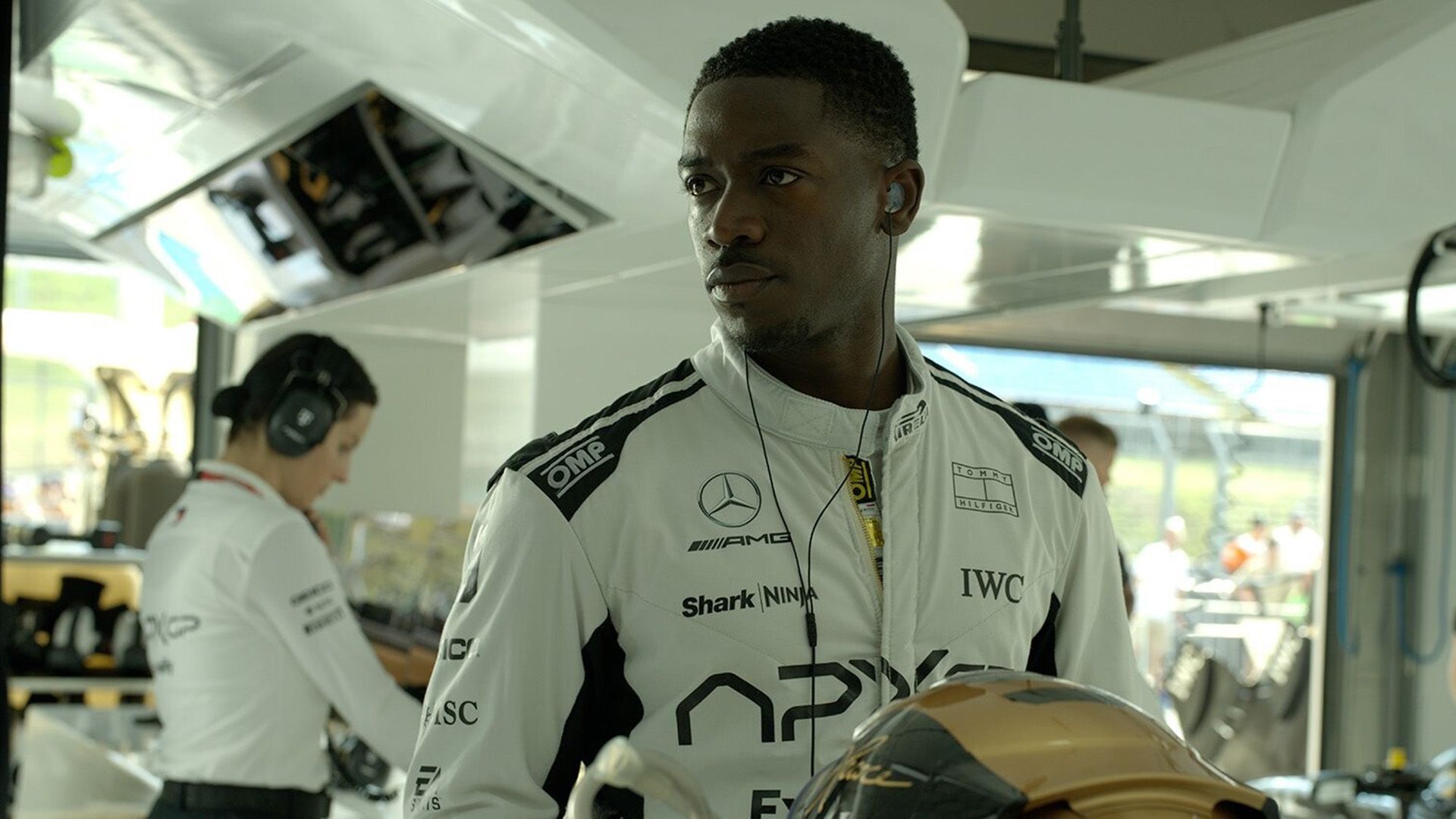 Damson Idris num fato de corrida branco