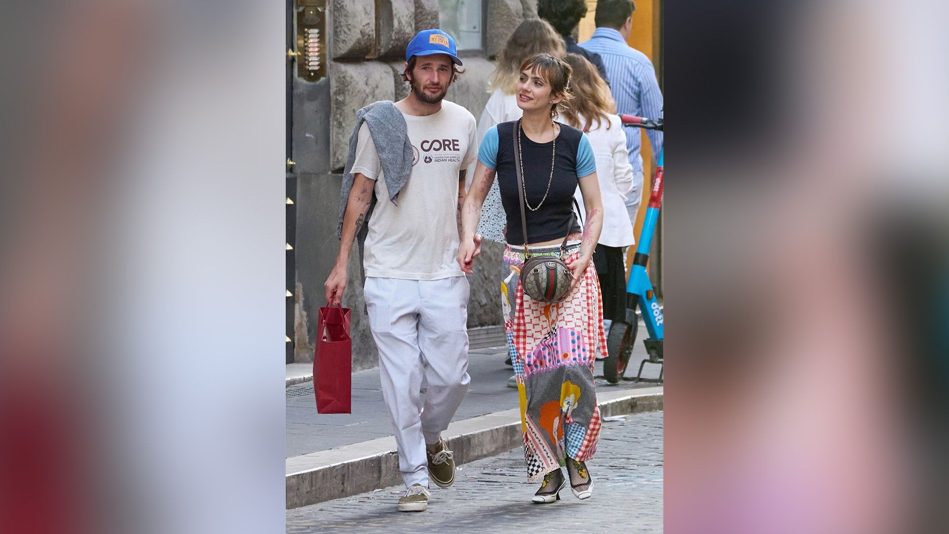 Zoe Bleu e Hopper Penn passeiam por uma rua da cidade, de mãos dadas