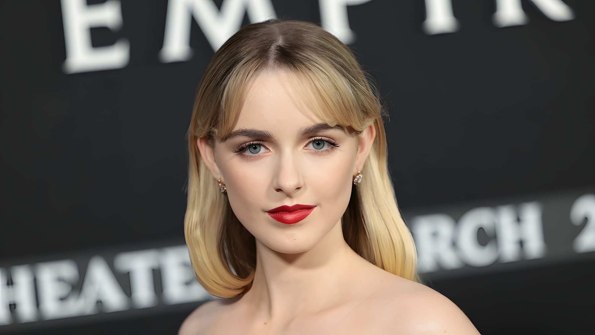 Mckenna Grace contra uma parede preta, rosto em grande plano