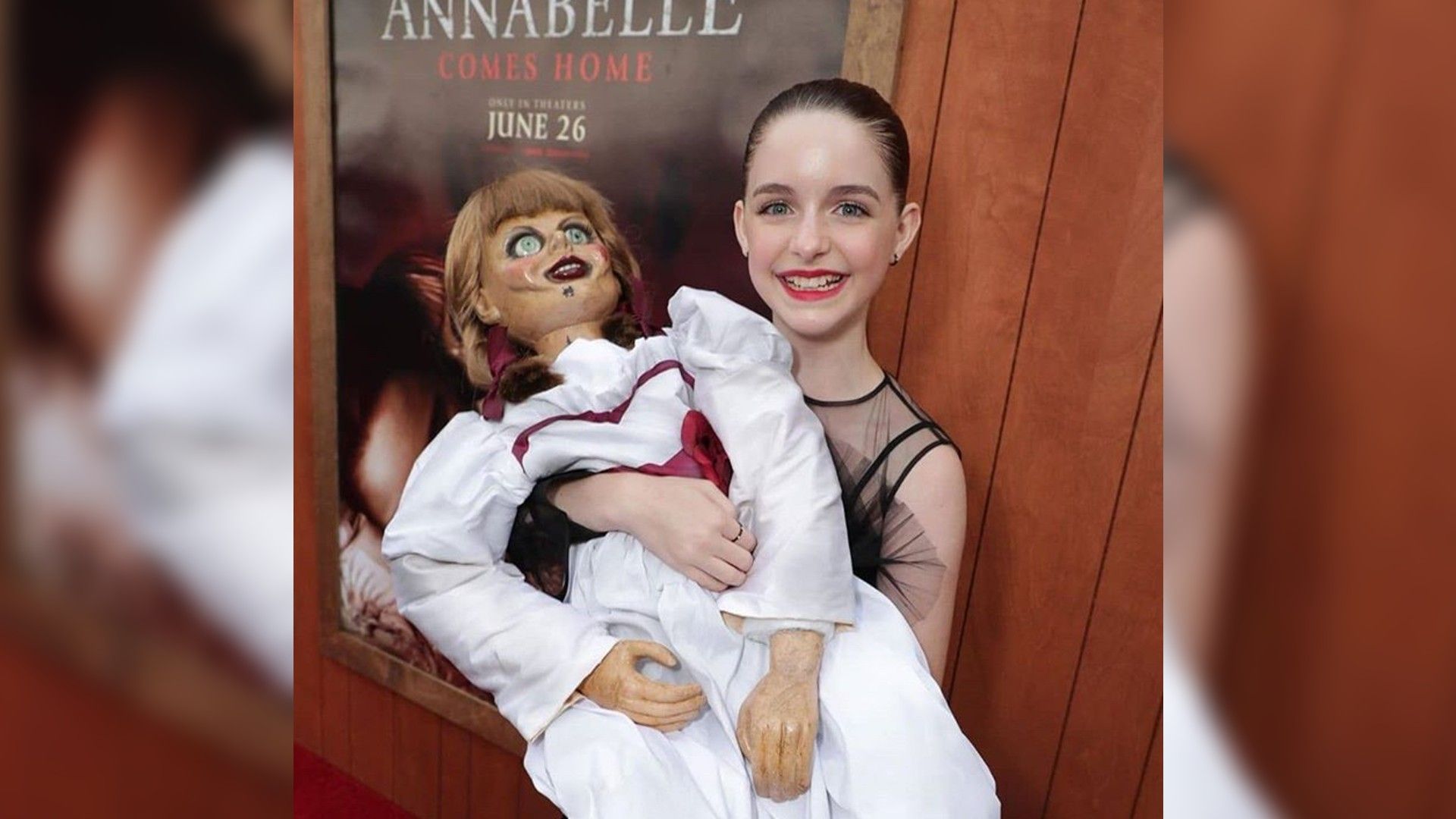 Mckenna Grace segura uma boneca assustadora e sorri