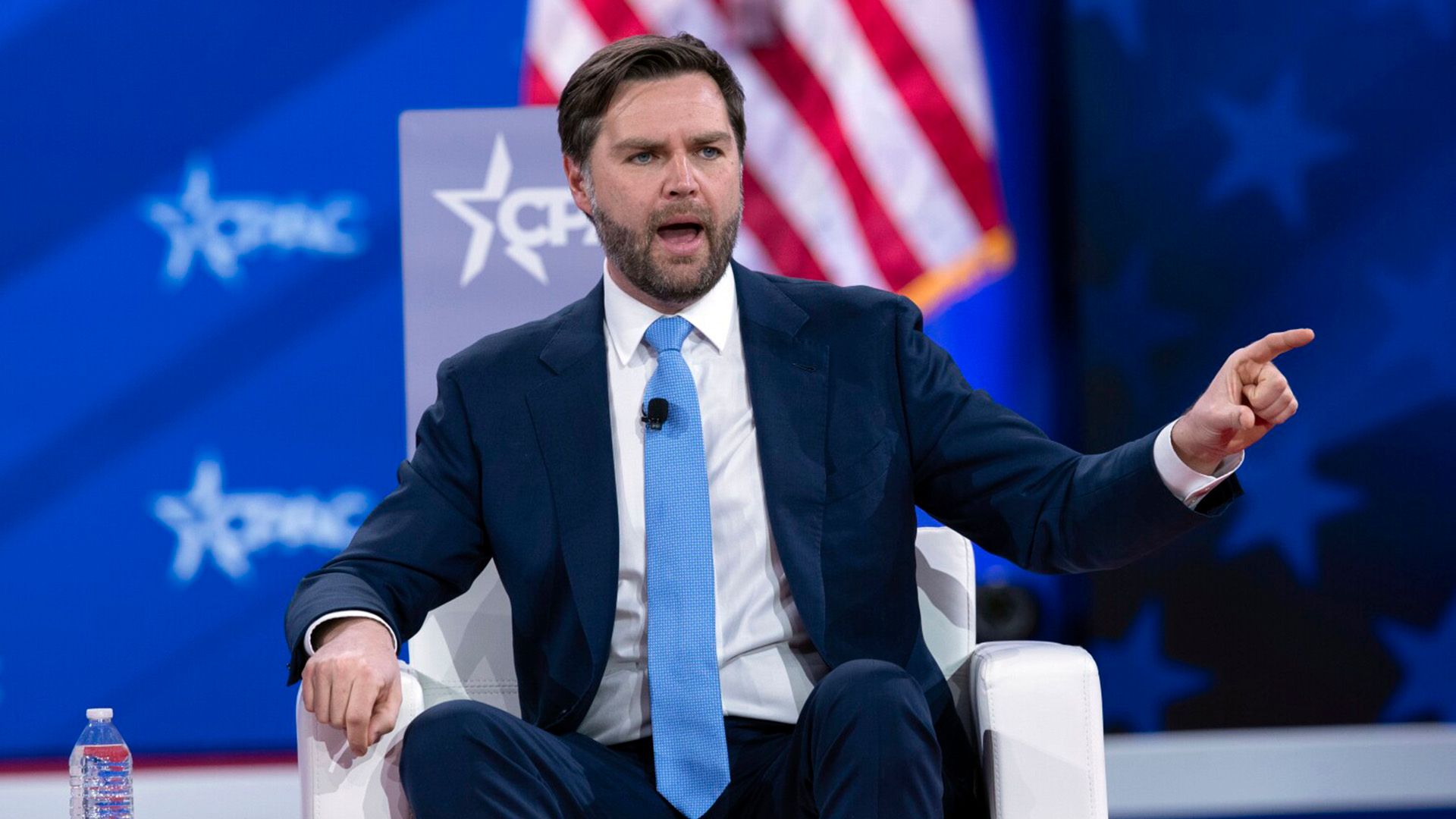 J.D. Vance numa cadeira branca no palco