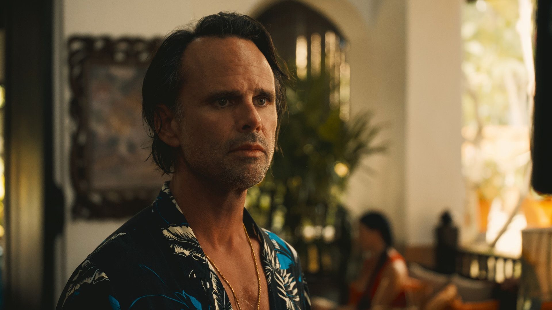 Walton Goggins numa camisa havaiana e com uma corrente de ouro ao pescoço