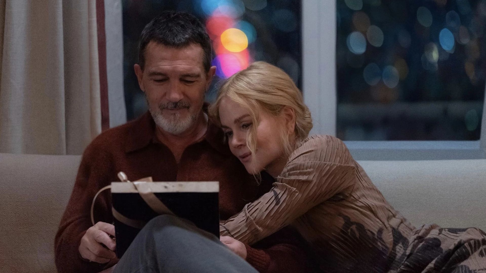 Antonio Banderas e Nicole Kidman sentados num sofá, abraçados