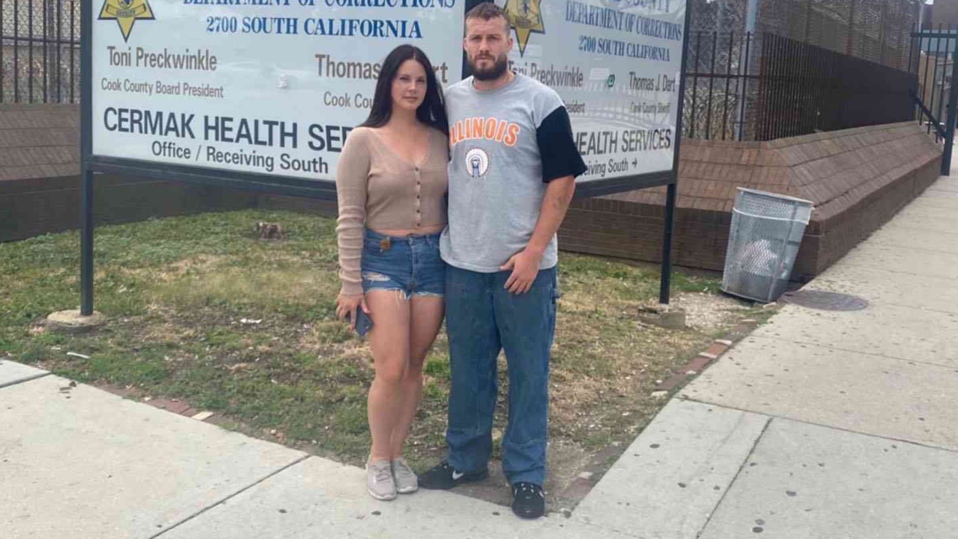 Lana Del Rey e Jack Donoghue. O casal está na rua junto a uma placa dos Cermak Health Services em Chicago