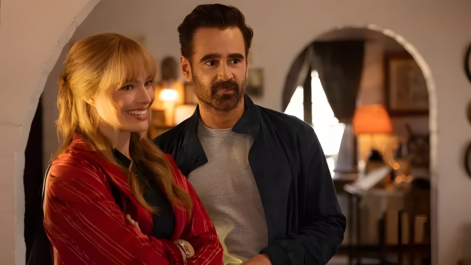 Margot Robbie e Colin Farrell lado a lado numa sala acolhedora com iluminação suave e calorosa
