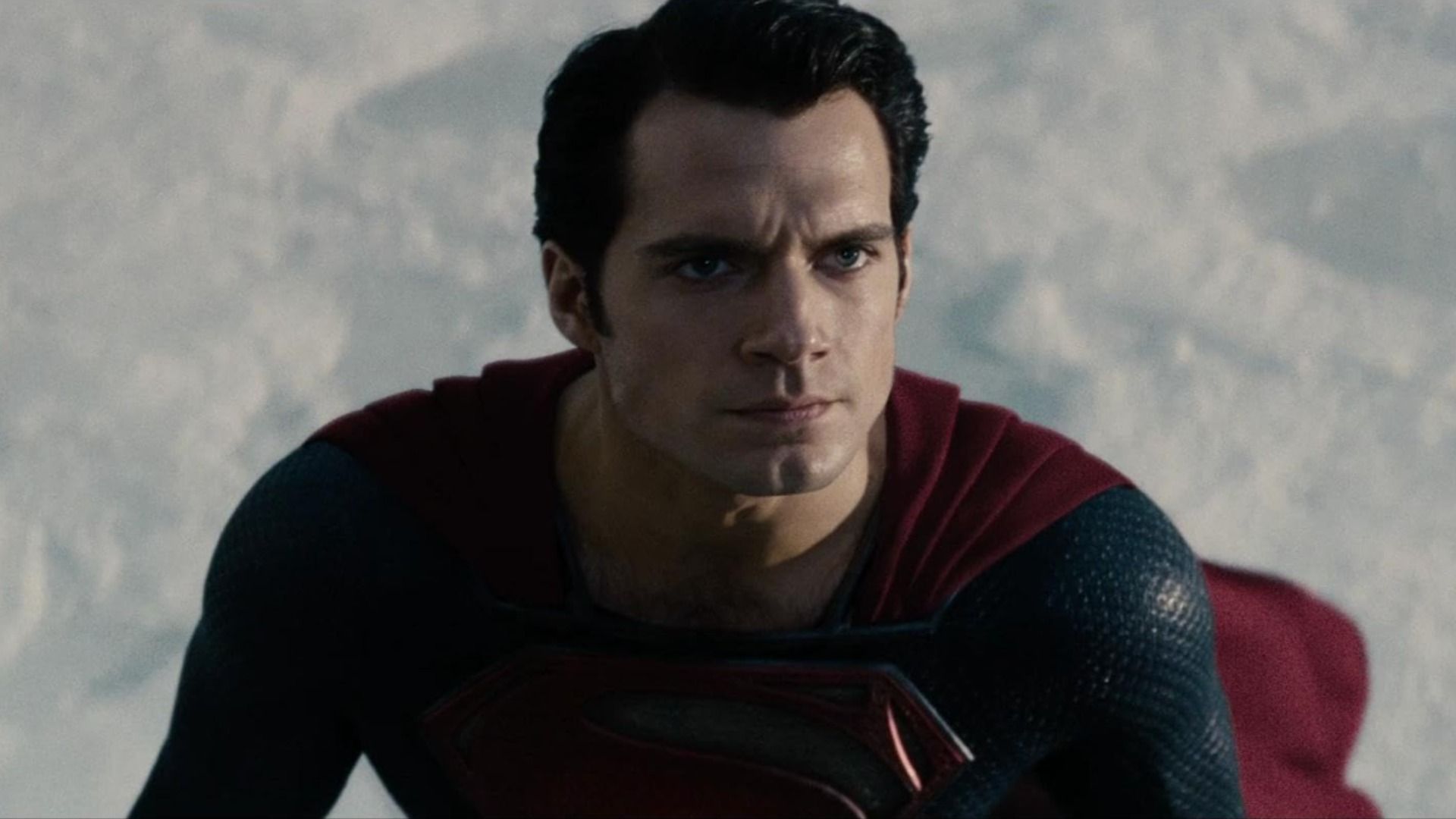 O ator Henry Cavill num fato de super-herói azul e vermelho com a letra S no peito