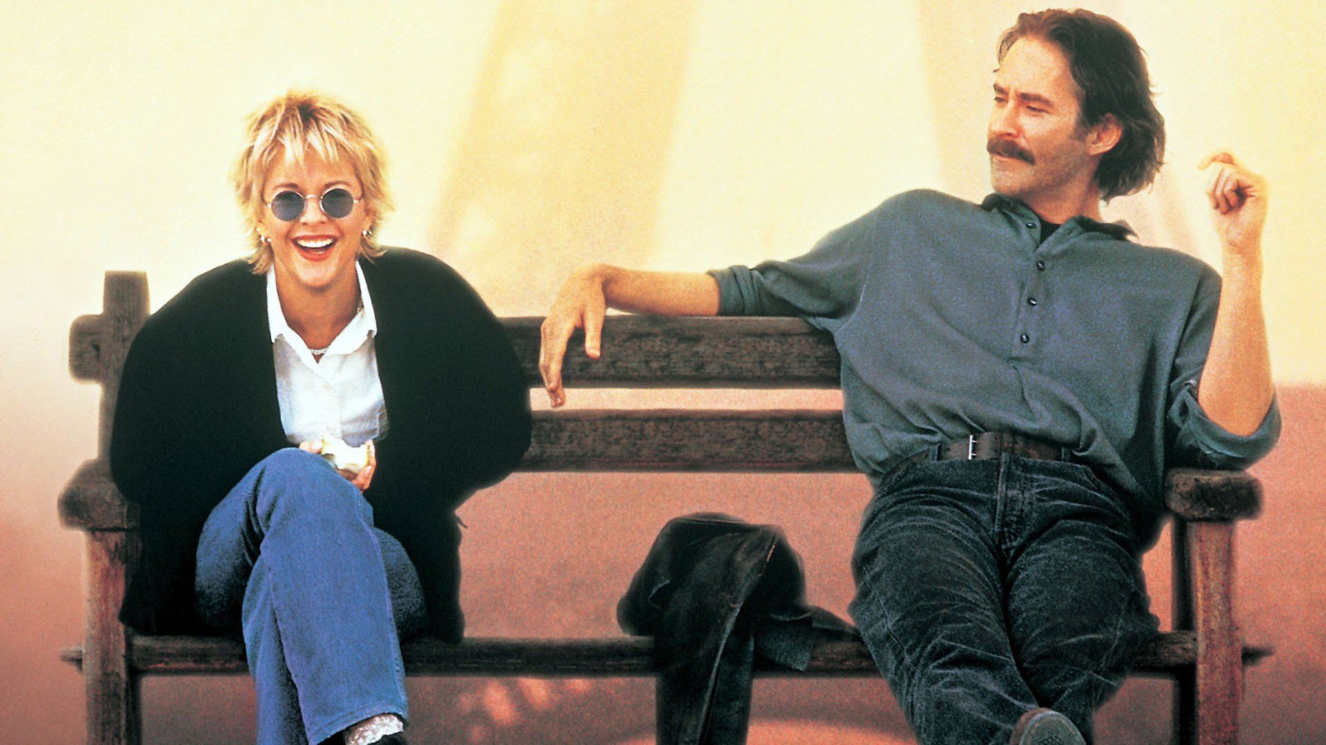 Meg Ryan e Kevin Kline sentados num banco, a conversar e a rir