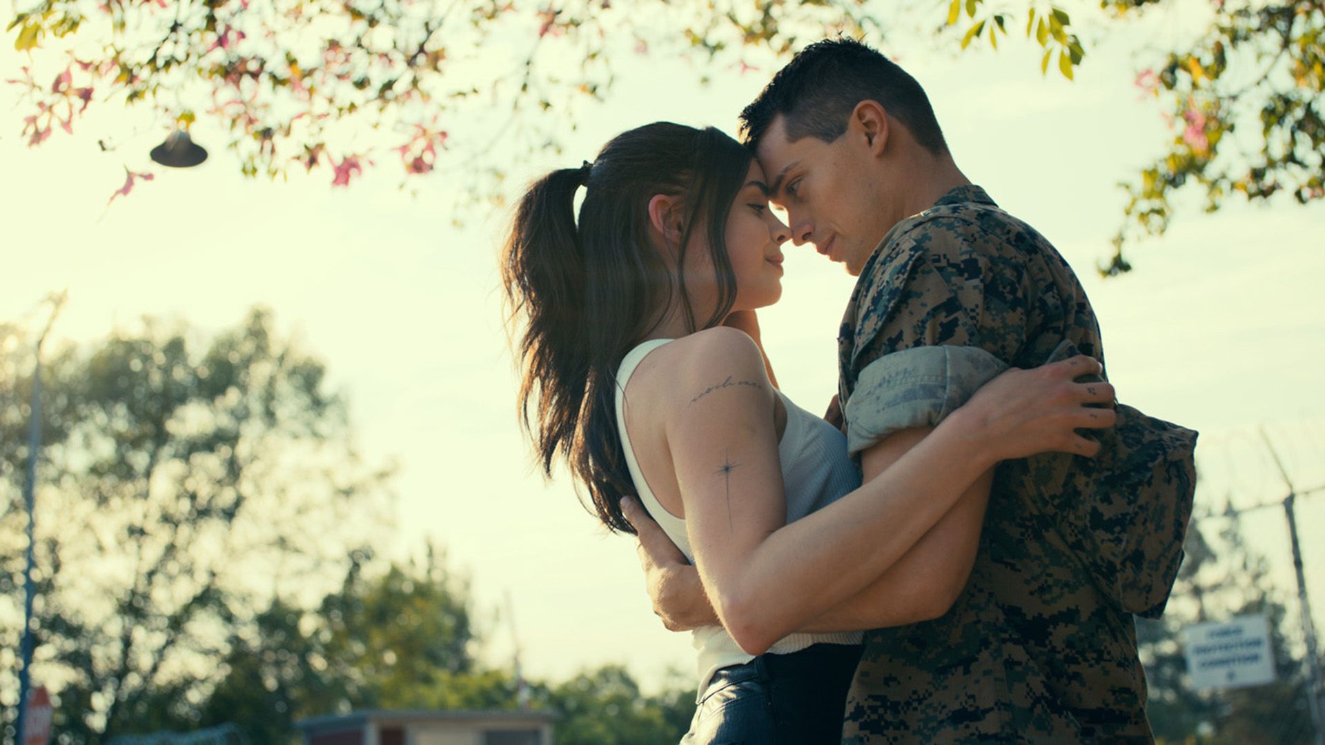 Sofia Carson e Nicholas Galitzine abraçam-se enquanto estão debaixo de uma árvore
