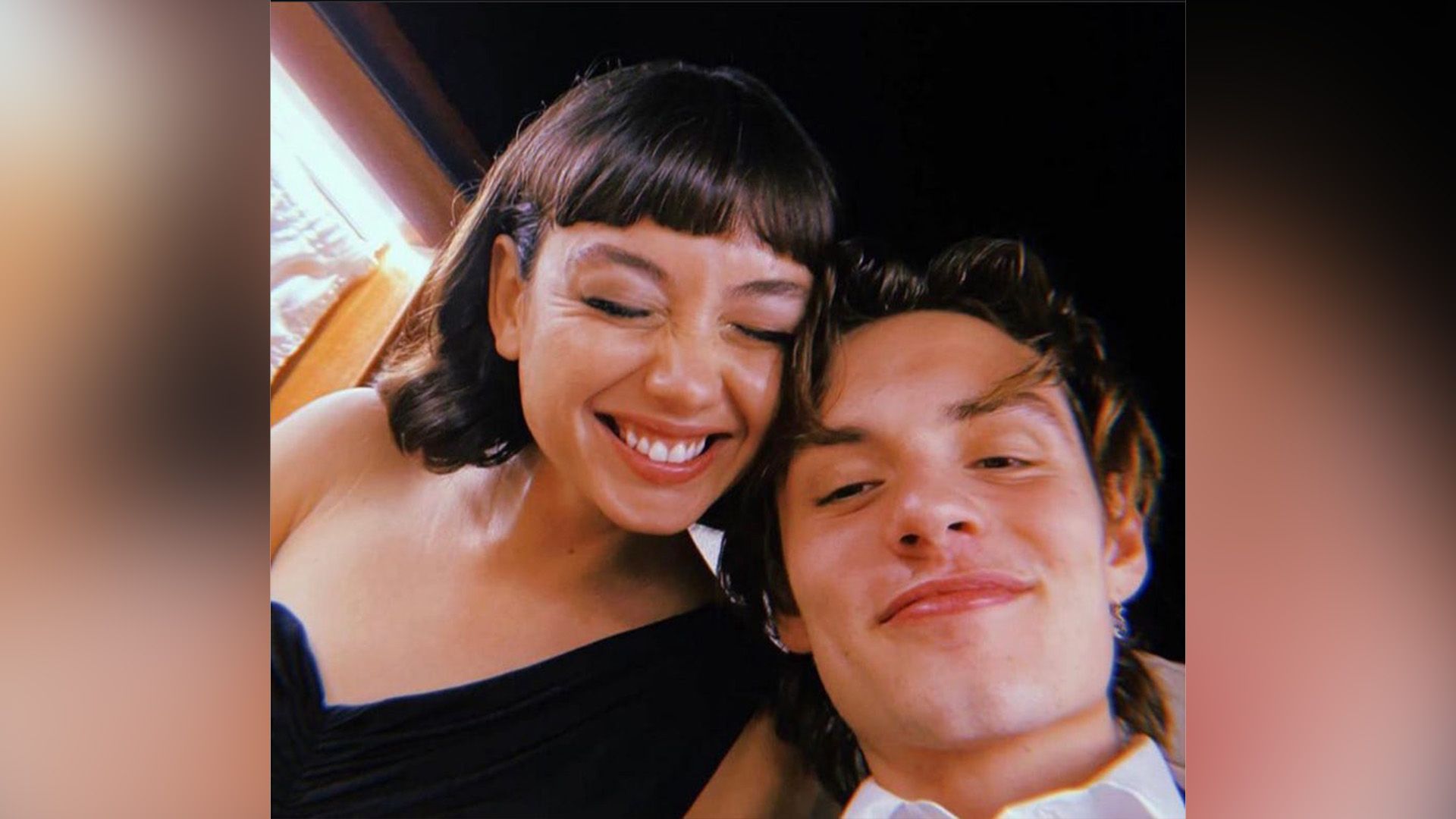 Sydney Chandler a rir e Louis Partridge a sorrir