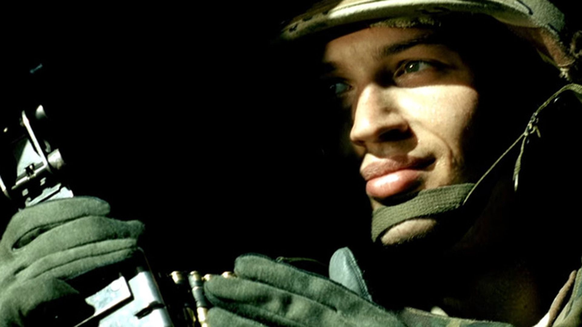 Tom Hardy de uniforme militar e capacete, rosto meio escondido na sombra