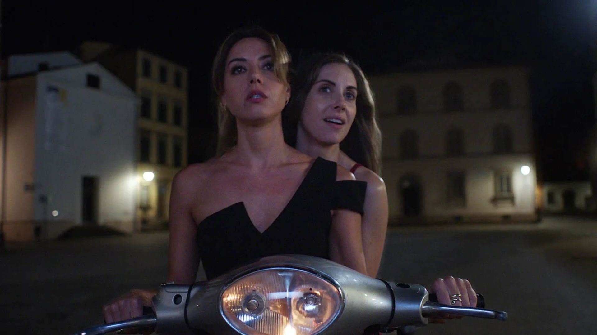 Alison Brie e Aubrey Plaza andam de moto no escuro, cena do filme "Spin Me Round"