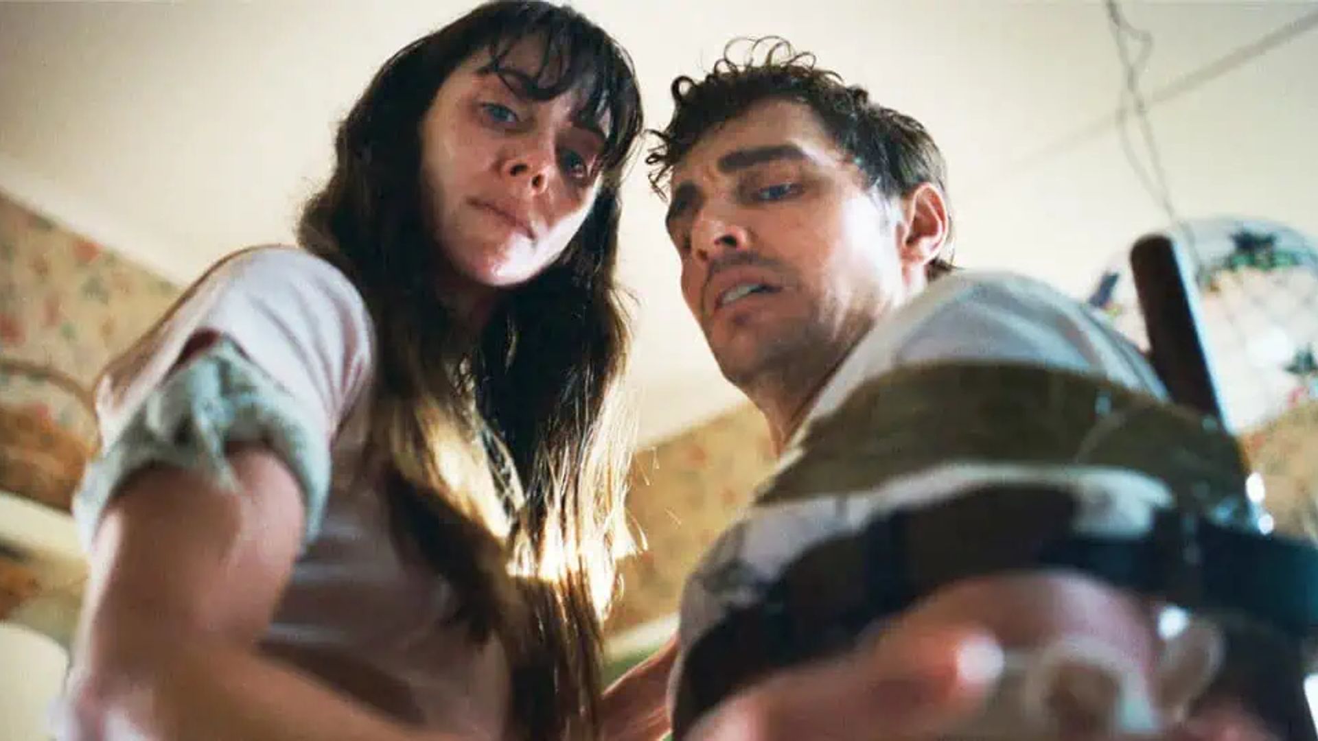 Dave Franco e Alison Brie olham para baixo em direção à câmara com expressões cansadas nos rostos