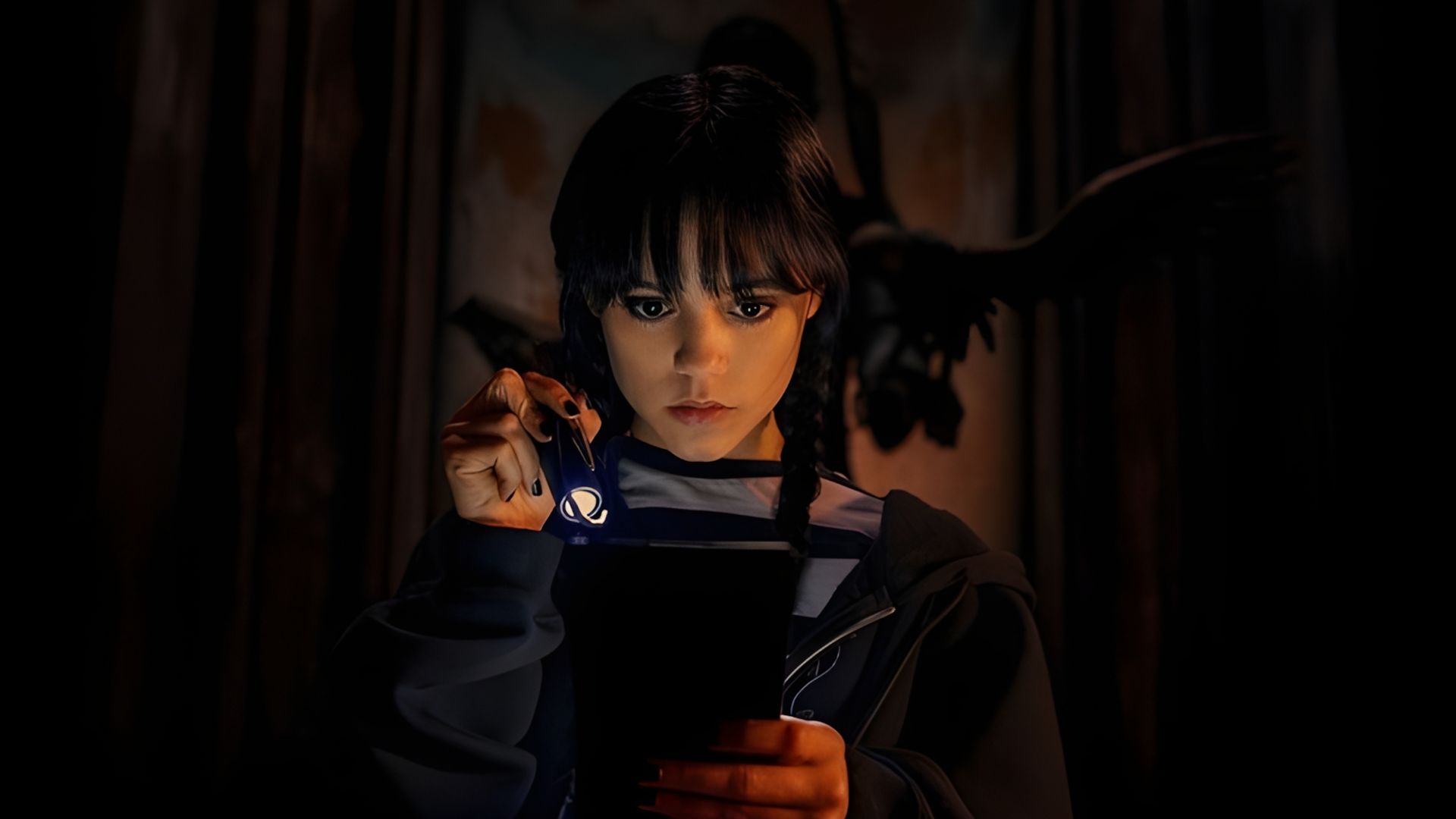Jenna Ortega como Wednesday Addams segurando uma lanterna e olhando para um livro