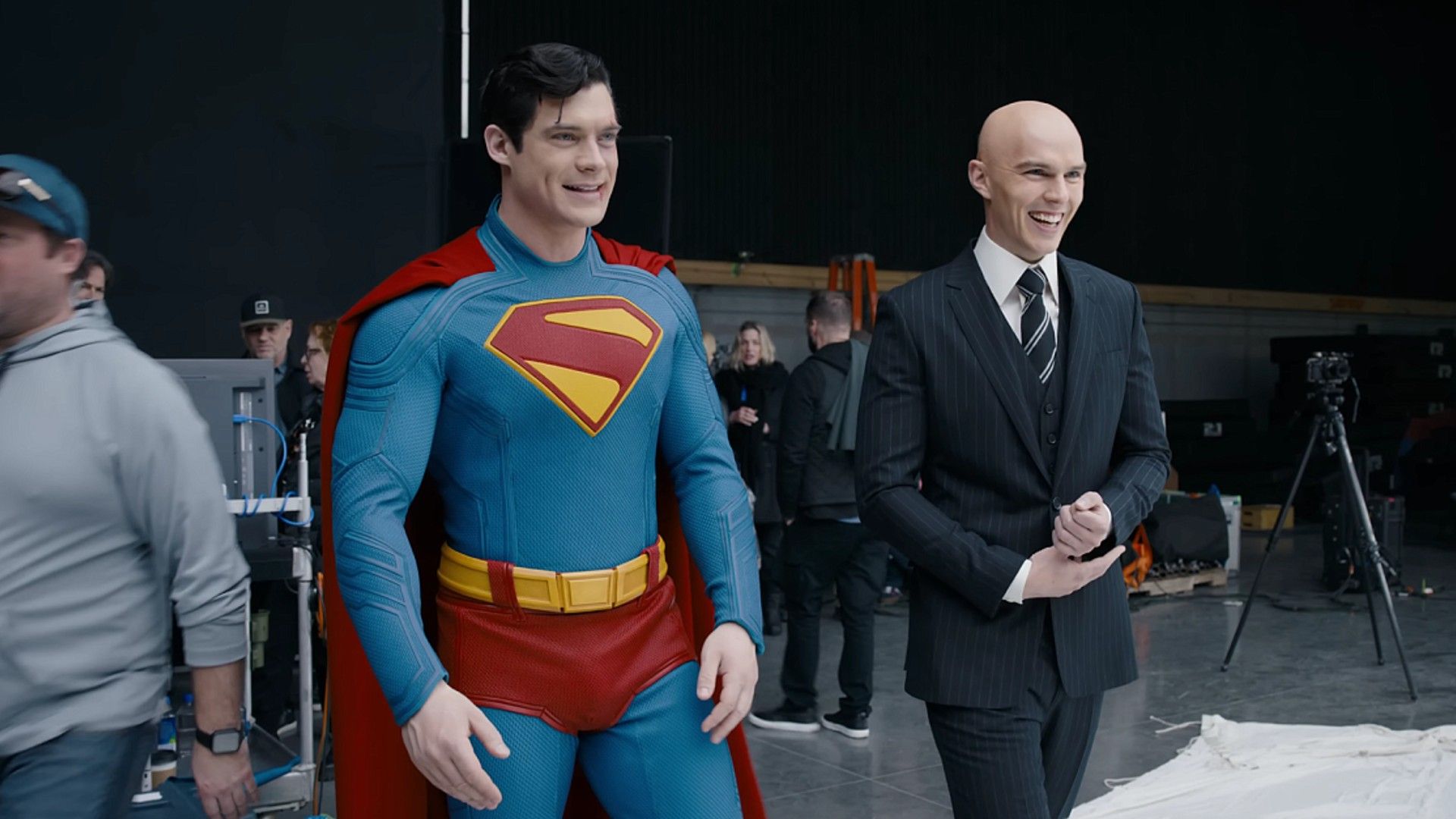 Nicholas Hoult de fato preto e David Corenswet no fato do Superman com capa vermelha