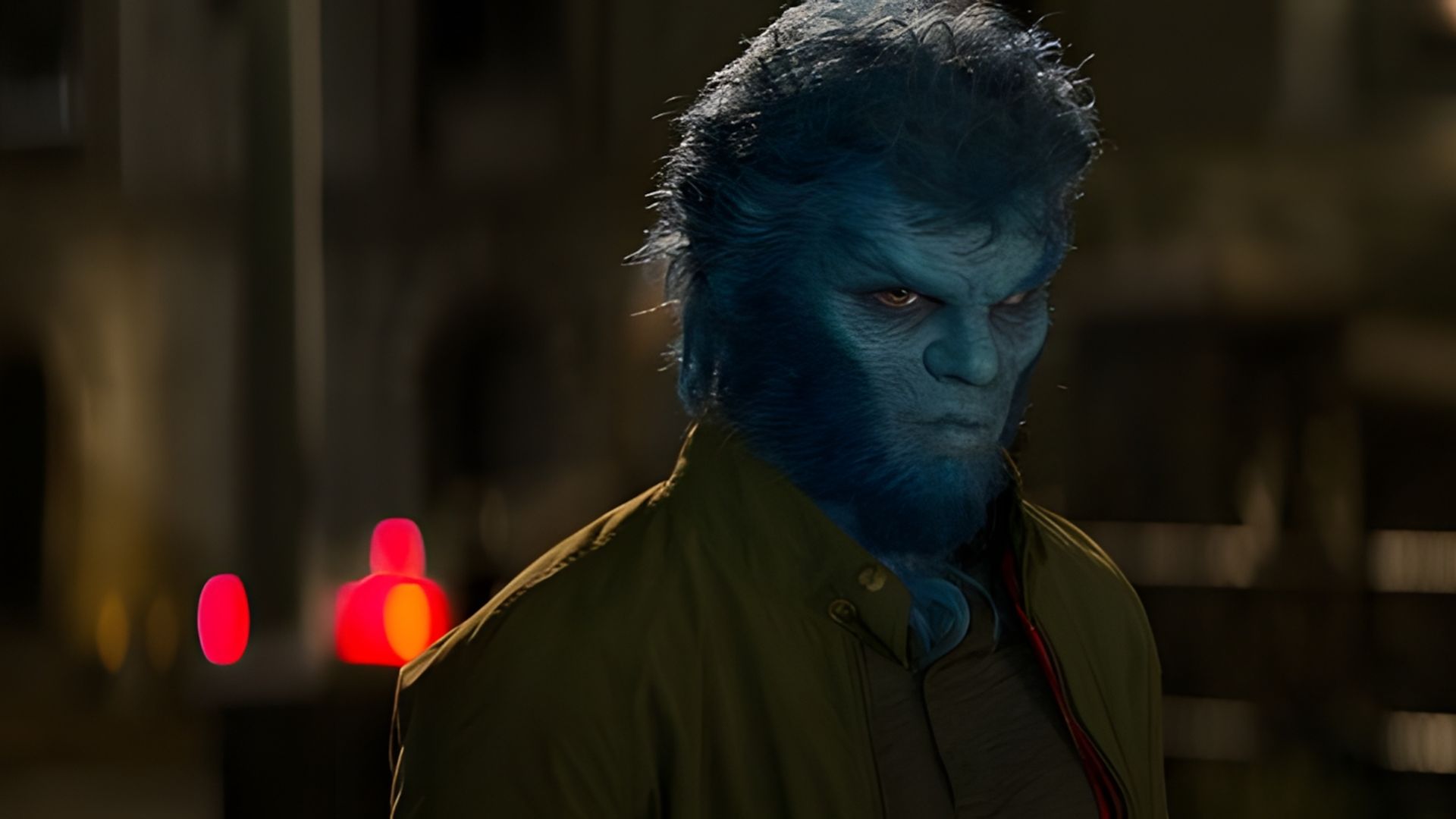 Nicholas Hoult com o rosto azul e pelo, num casaco verde, de pé à noite numa rua escura