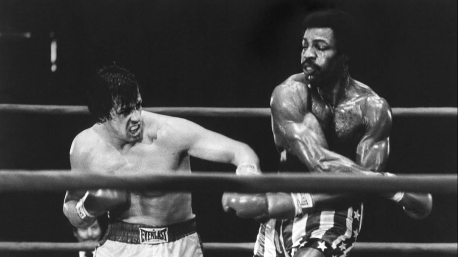 O ator Carl Weathers luta num ringue de boxe com o ator Sylvester Stallone