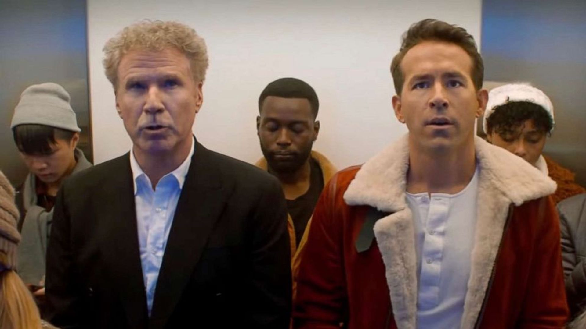 Ryan Reynolds e Will Ferrell num elevador olhando para o mesmo ponto