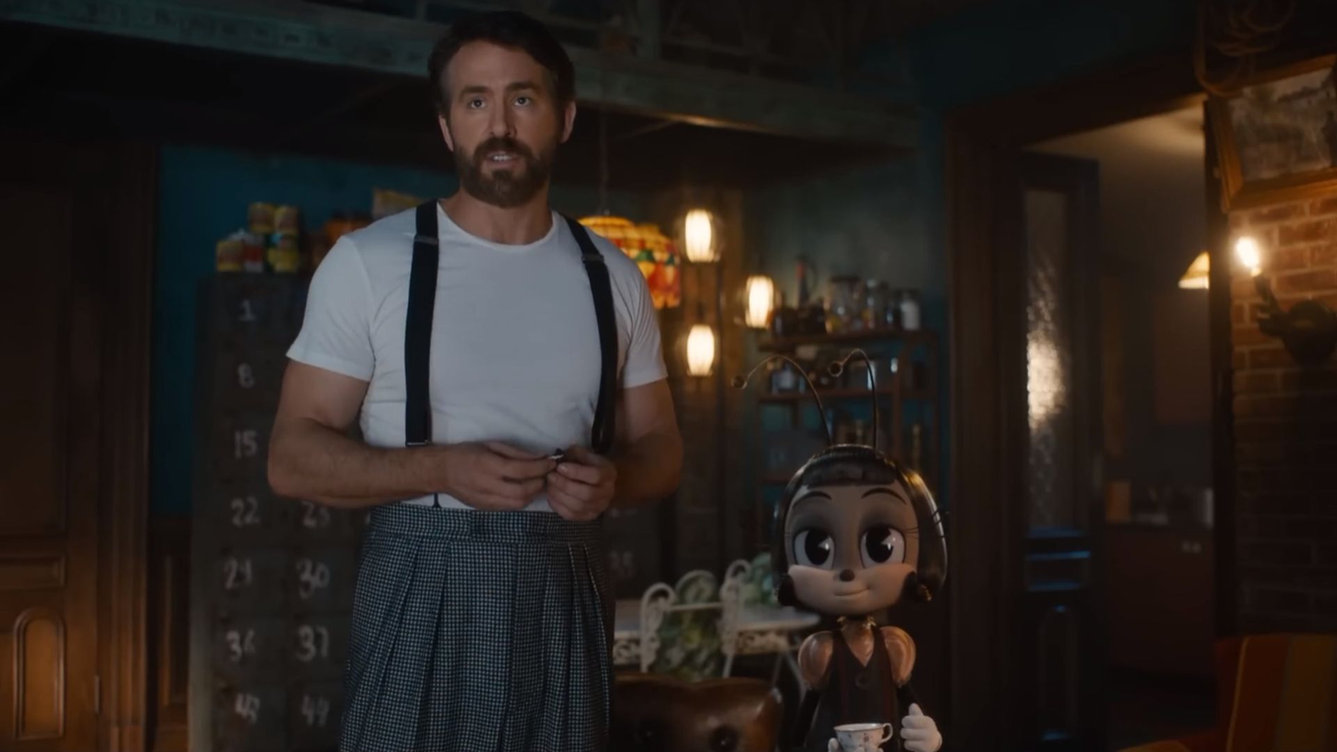 Ryan Reynolds numa t-shirt branca com suspensórios ao lado de uma personagem de formiga dos desenhos animados segurando uma chávena de chá