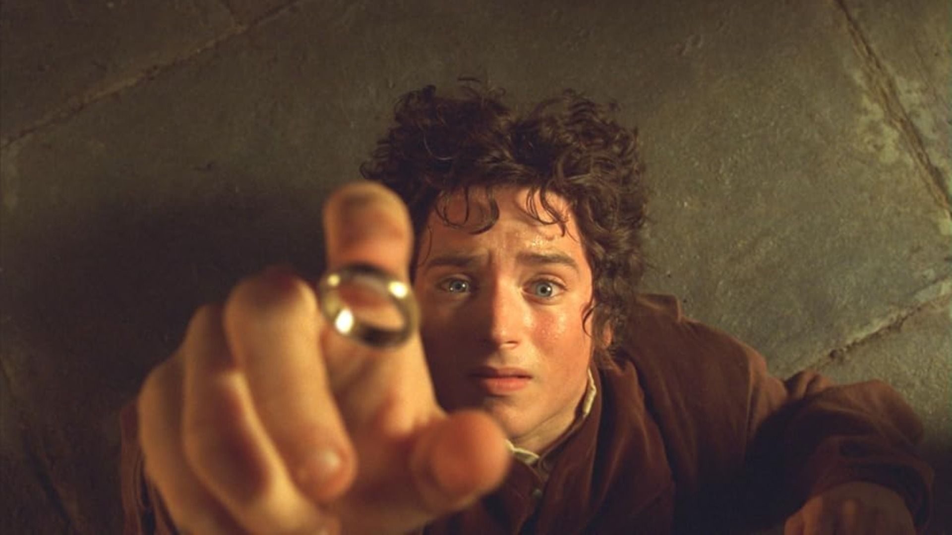 O ator Elijah Wood estende a mão para o anel dourado em terror, caindo no chão
