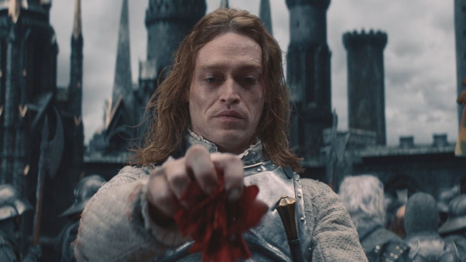 Caleb Landry Jones com maquilhagem de vampiro olha para baixo com desprezo
