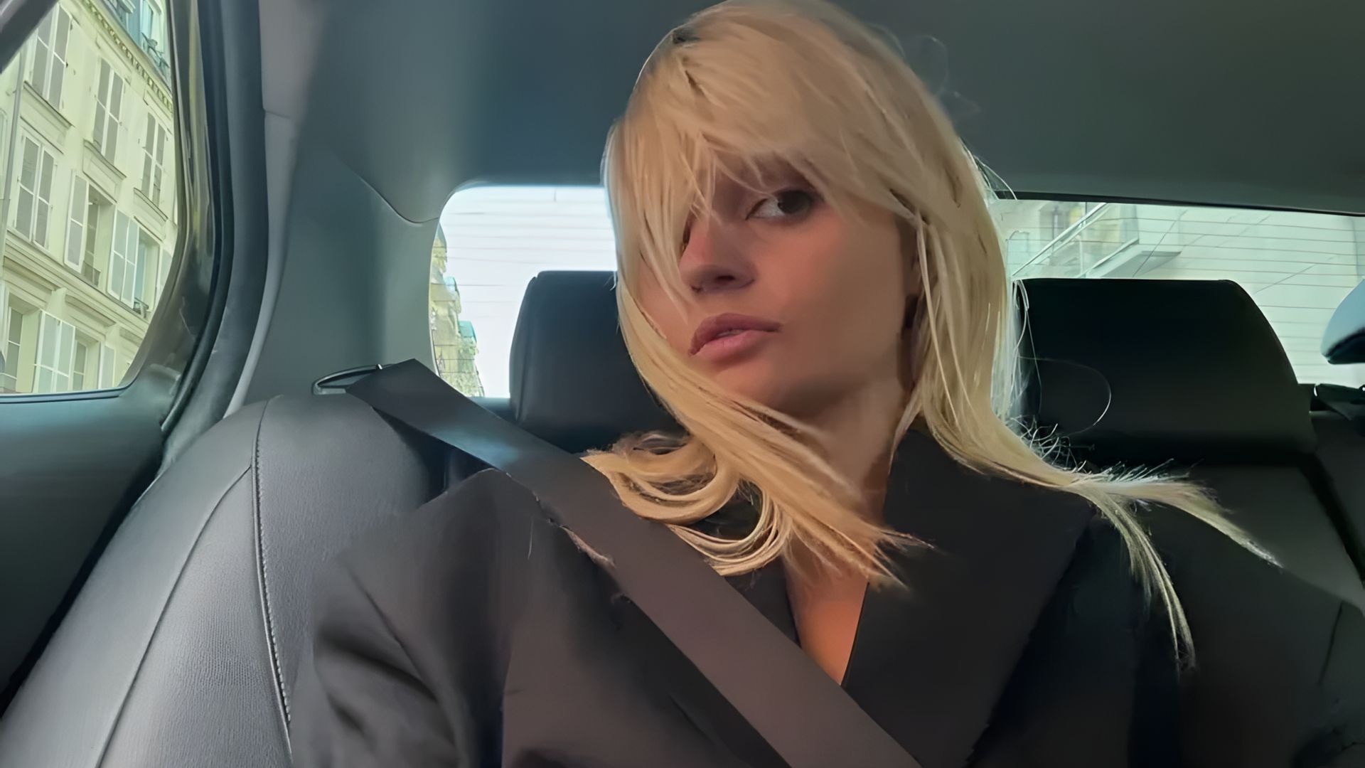 Loira com corte bob no banco do passageiro de um carro