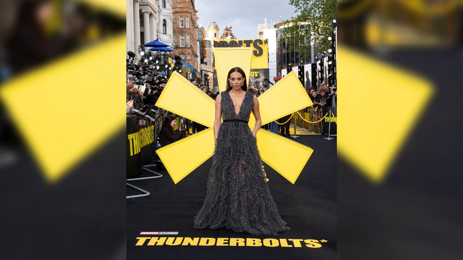 Hannah John-Kamen num vestido longo contra o pano de fundo de uma estrela amarela gigante