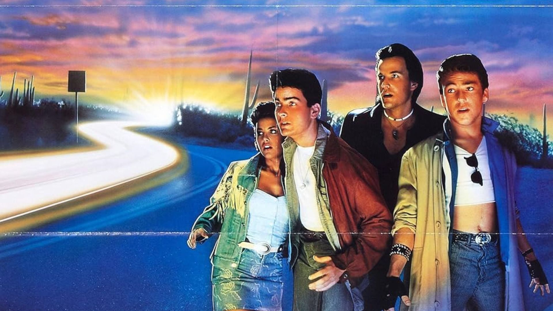Ator Charlie Sheen numa jaqueta vermelha de pé na estrada com uma rapariga e dois homens